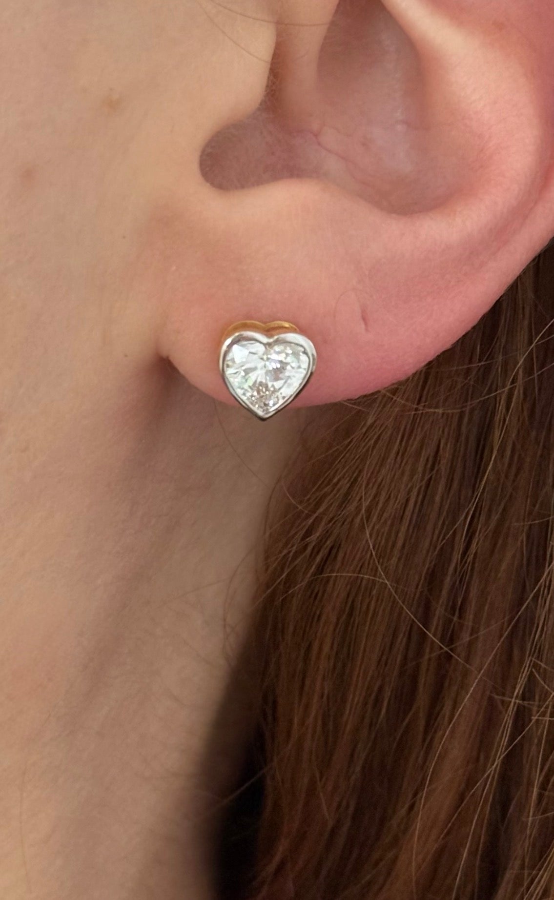 Yellow gold bezel set heart shape lab diamond stud earrings. Tops of bezel settings are white gold.