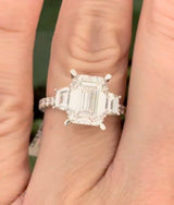 White gold emerald cut, trapezoid, and round lab diamond ring. Center stone is 4.06cts