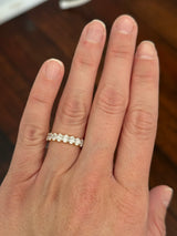 Yellow gold 3.02ct oval lab diamond eternity band. Prongs are white gold.