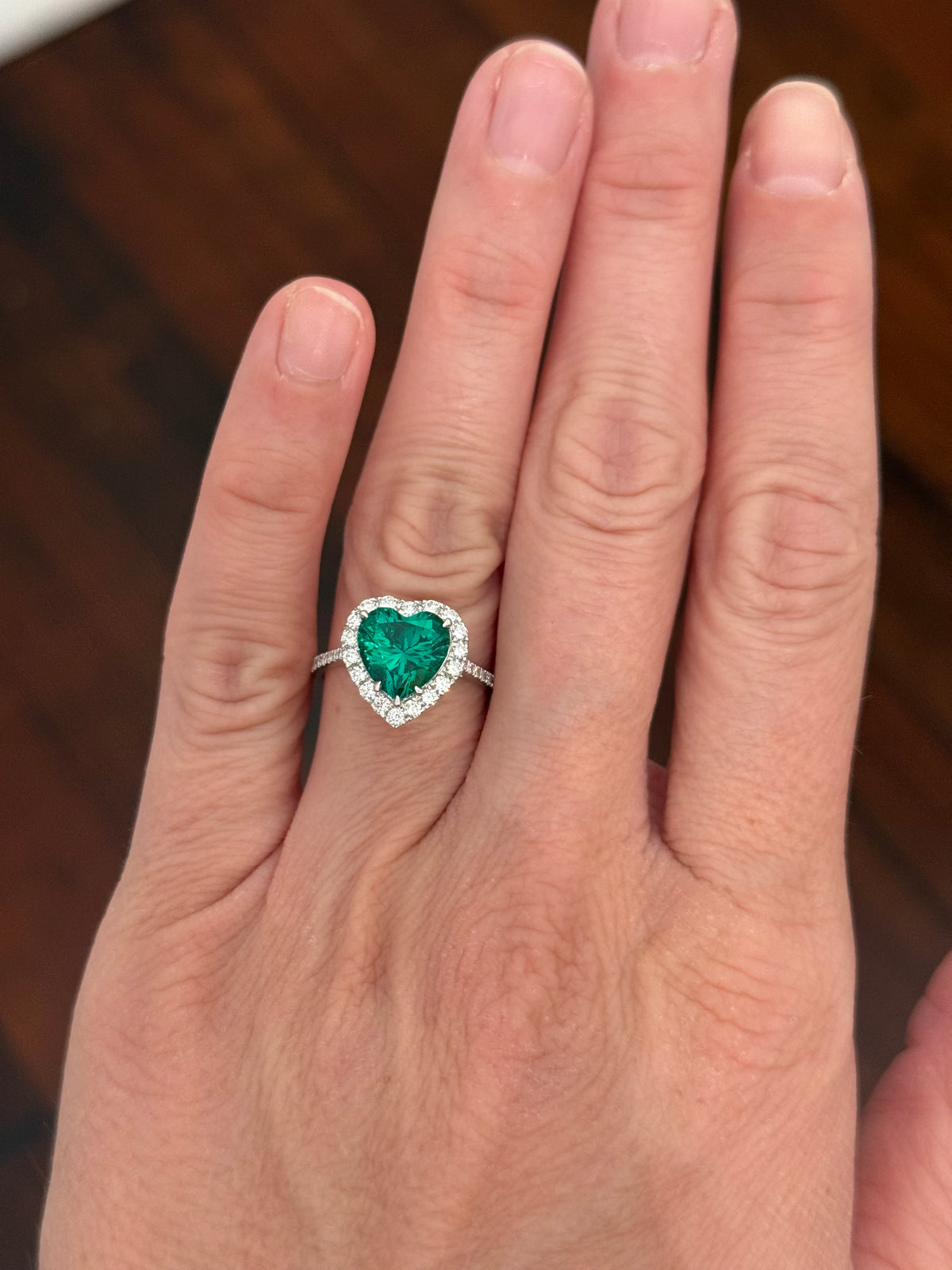 White gold heart shaped lab emerald and round lab diamond ring. Center stone is 2.32cts