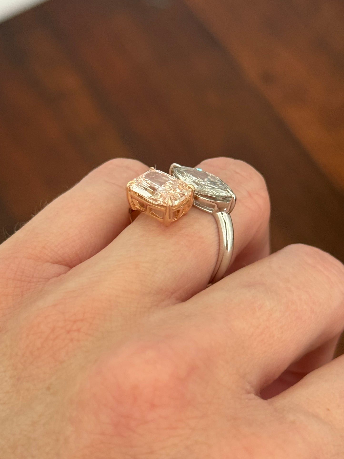 Rose and white gold cushion pink lab diamond and white marquise lab diamond toi et moi ring. Pink lab diamond is set in rose gold and white lab diamond is set in white gold.
