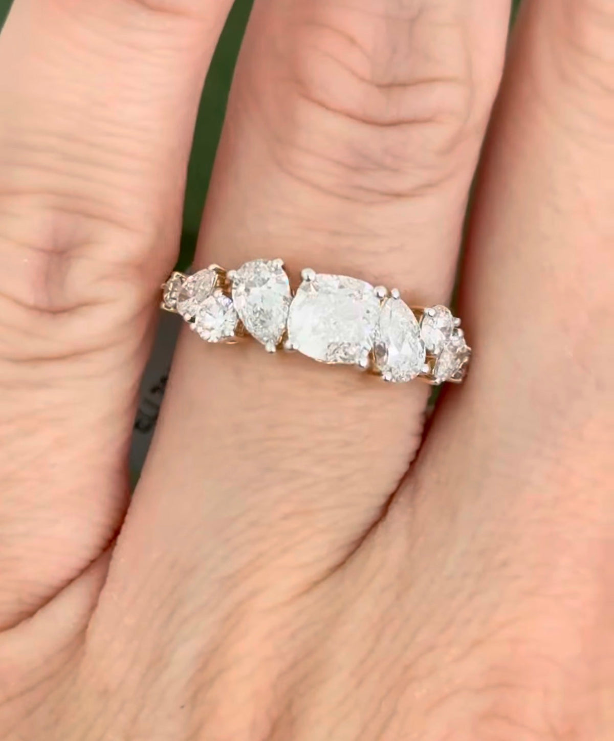 Yellow gold cushion, pear shape and round lab diamond ring. Prongs are white gold.