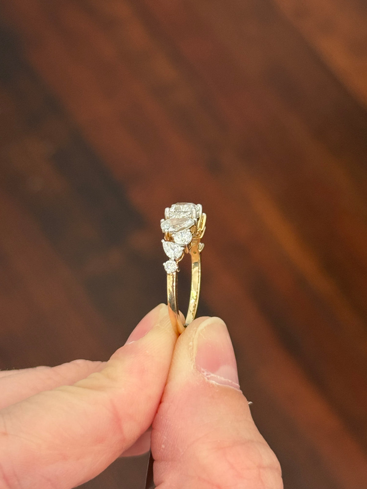 Yellow gold cushion, pear shape and round lab diamond ring. Prongs are white gold.
