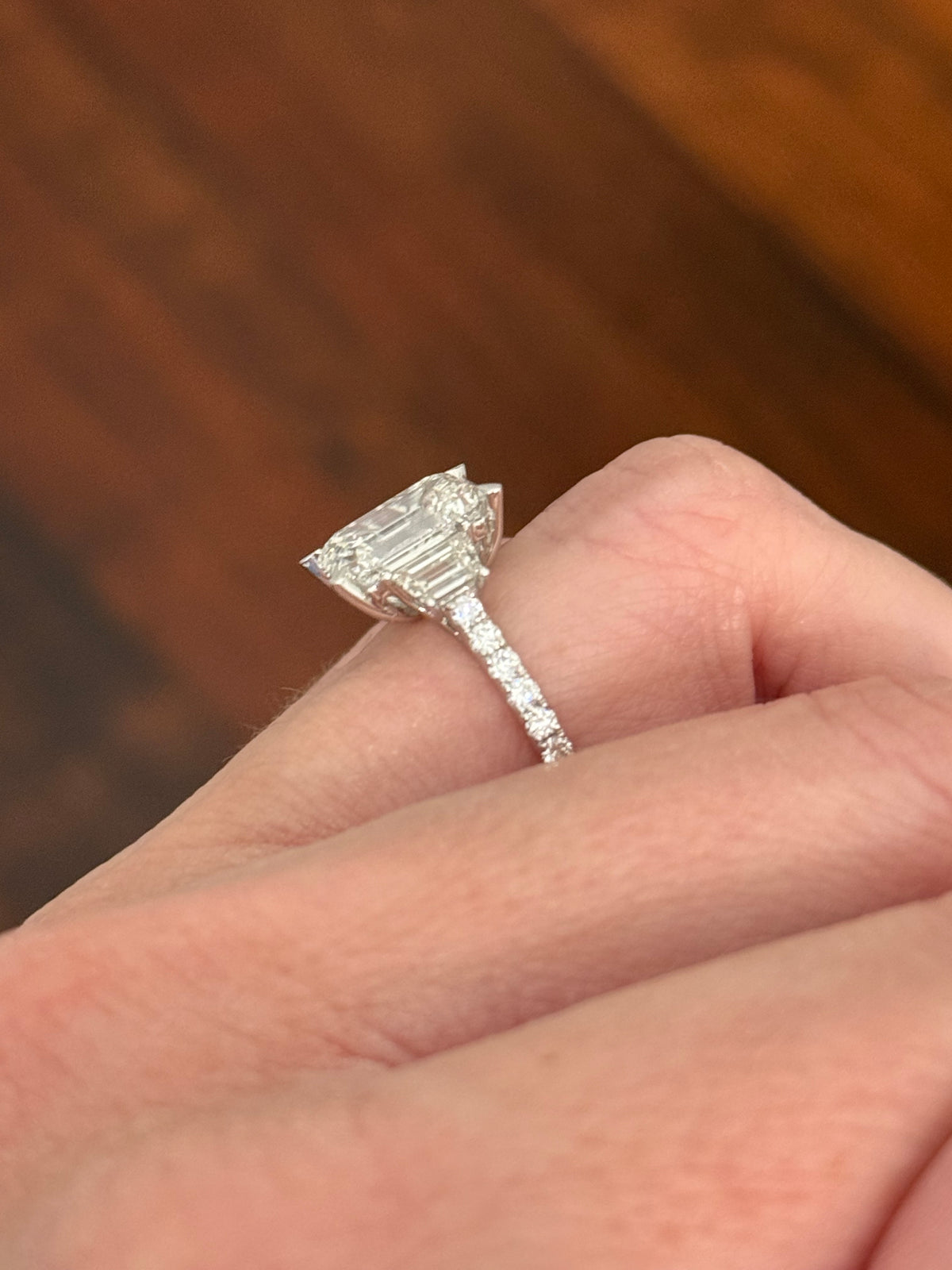 White gold emerald cut, trapezoid, and round lab diamond ring. Center stone is 4.06cts