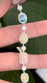 White gold mixed shape bracelet with radiant and marquise pink lab diamonds, oval blue lab diamonds, oval cushion and pear shaped yellow lab diamonds, and round white lab diamonds
