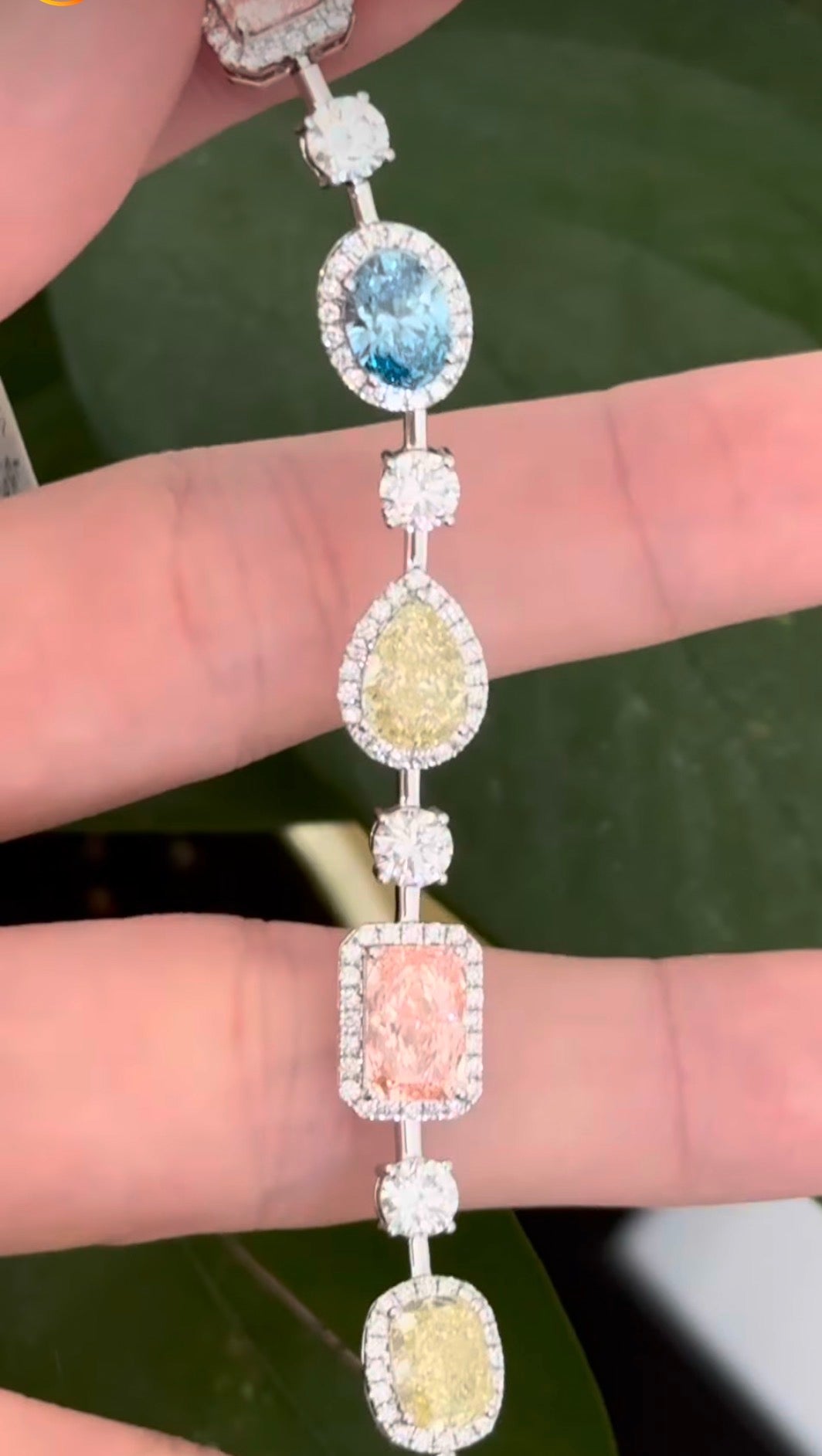 White gold mixed shape bracelet with radiant and marquise pink lab diamonds, oval blue lab diamonds, oval cushion and pear shaped yellow lab diamonds, and round white lab diamonds