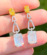 White and yellow gold oval yellow lab diamond and emerald cut and round white lab diamond dangle earrings