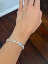 White gold mixed shape bracelet with radiant and marquise pink lab diamonds, oval blue lab diamonds, oval cushion and pear shaped yellow lab diamonds, and round white lab diamonds