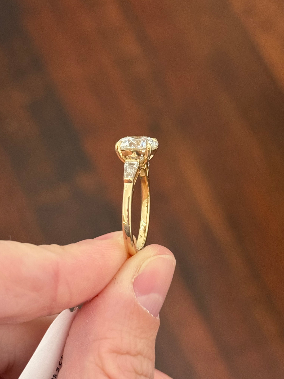 Yellow gold IGI certified 3.0ct round lab diamond and tapered baguette lab diamond ring. Round measures 9.18x5.71mm