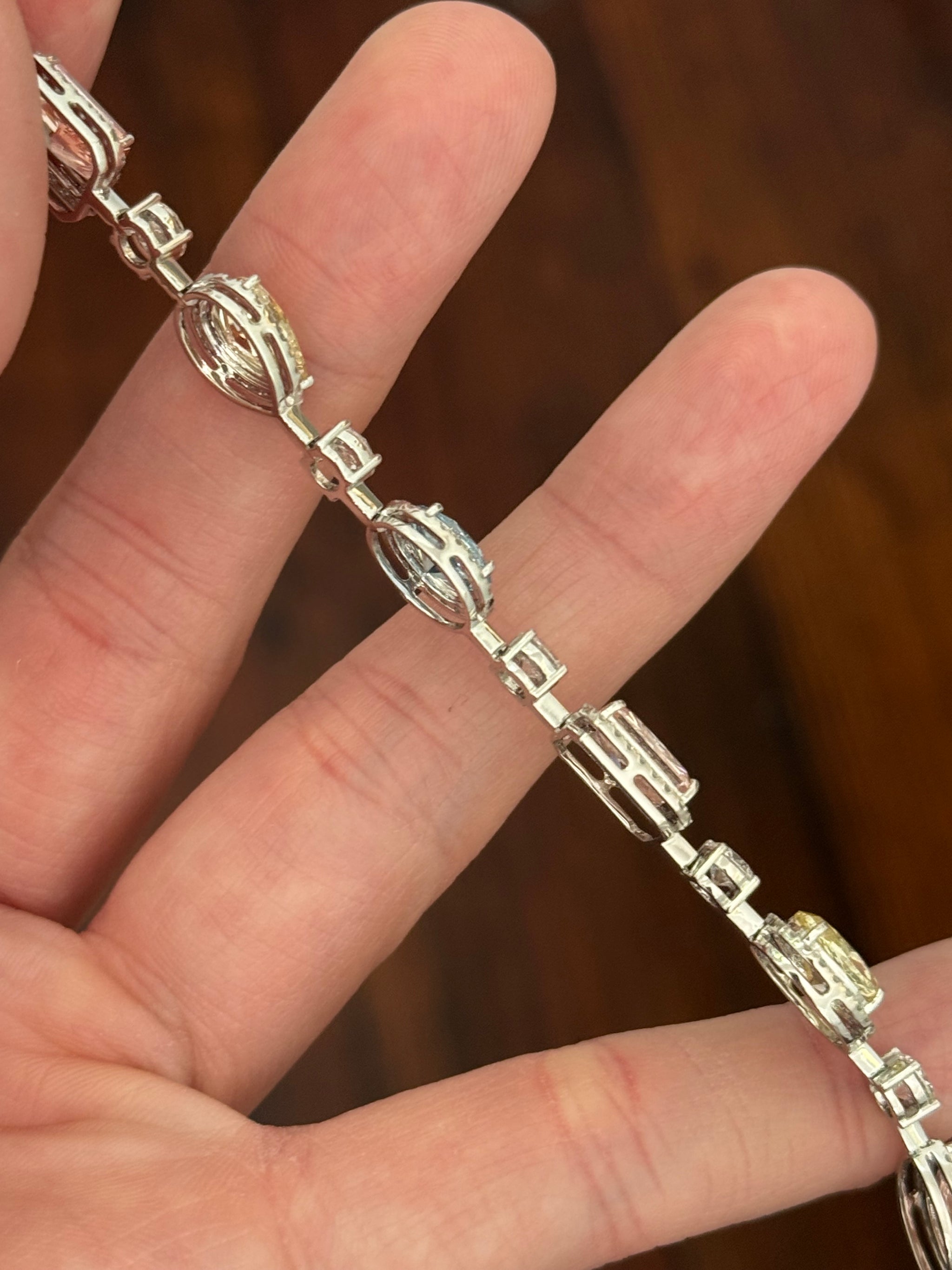 White gold mixed shape bracelet with radiant and marquise pink lab diamonds, oval blue lab diamonds, oval cushion and pear shaped yellow lab diamonds, and round white lab diamonds