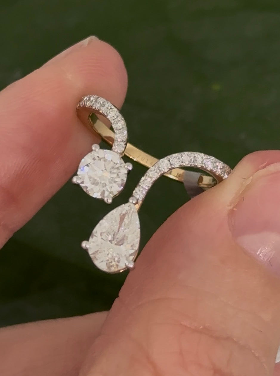 Yellow gold pear shape and round lab diamond ring. Prongs are white gold.