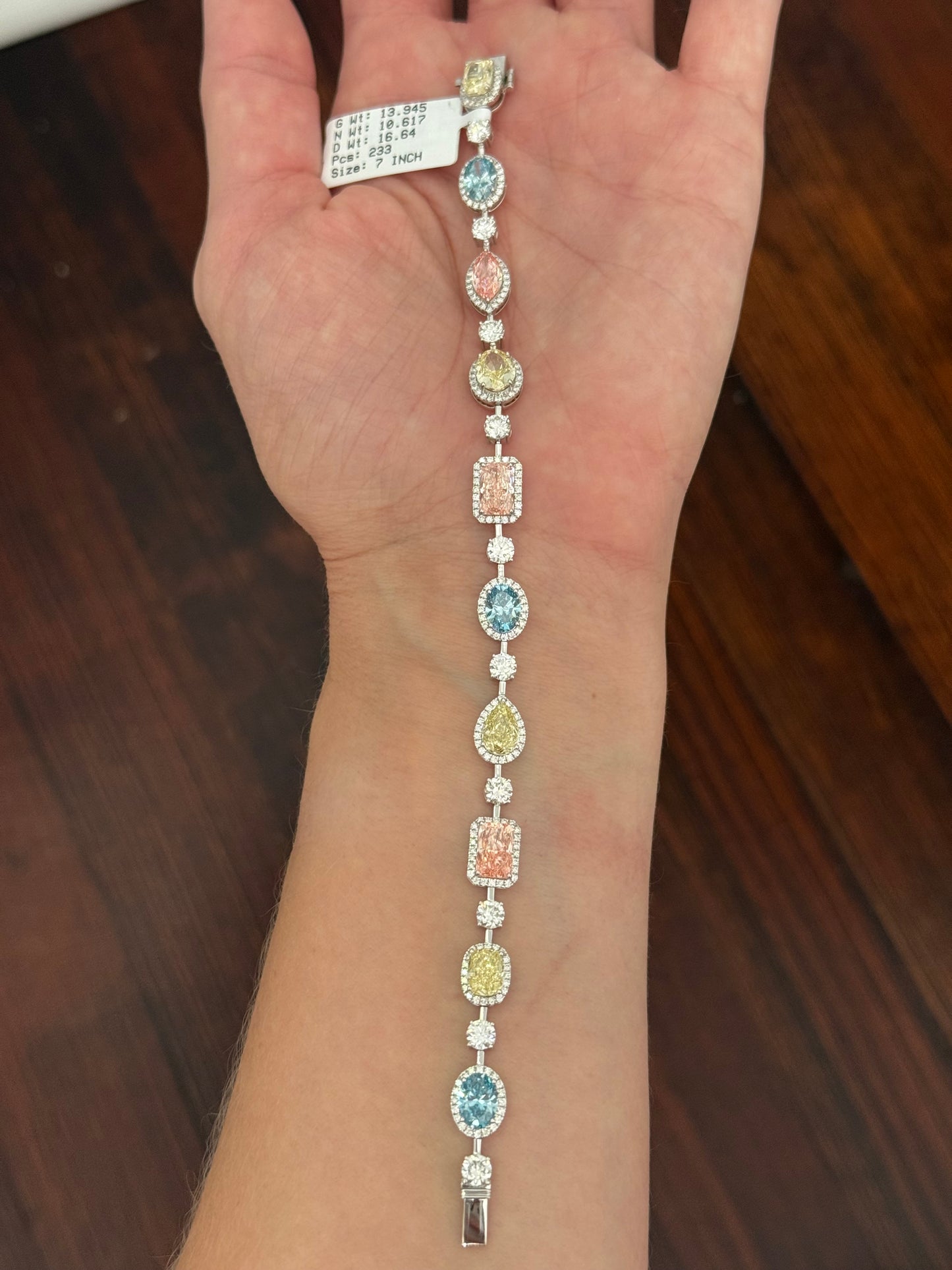 White gold mixed shape bracelet with radiant and marquise pink lab diamonds, oval blue lab diamonds, oval cushion and pear shaped yellow lab diamonds, and round white lab diamonds