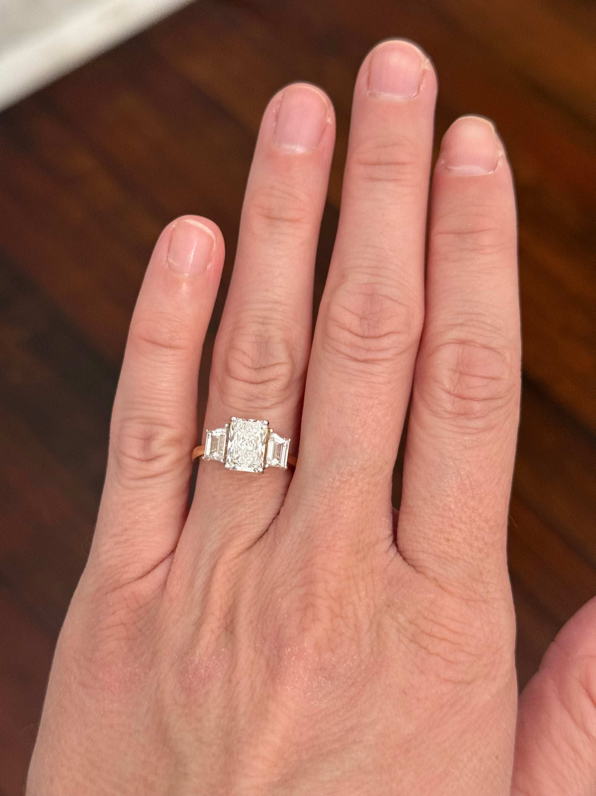 Yellow gold radiant and trapezoid lab diamond ring. Prongs are white gold.