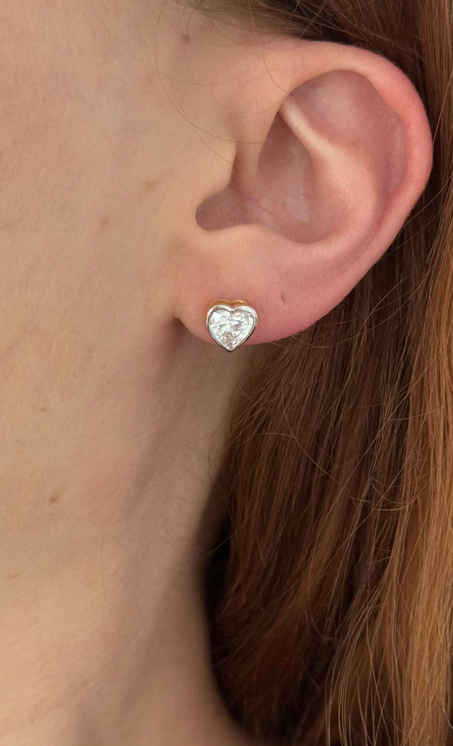 Yellow gold bezel set heart shape lab diamond stud earrings. Tops of bezel settings are white gold.