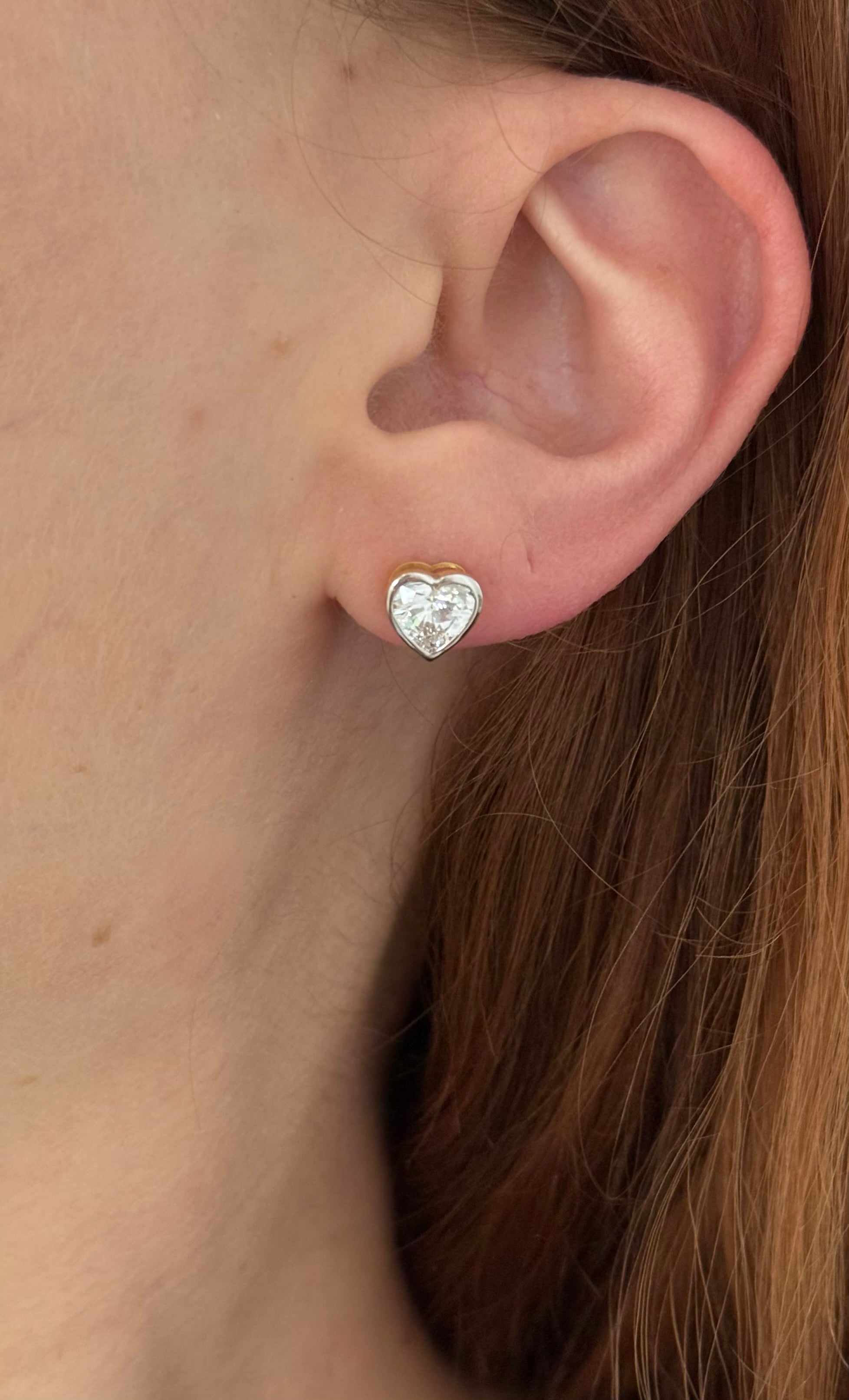 Yellow gold bezel set heart shape lab diamond stud earrings. Tops of bezel settings are white gold.