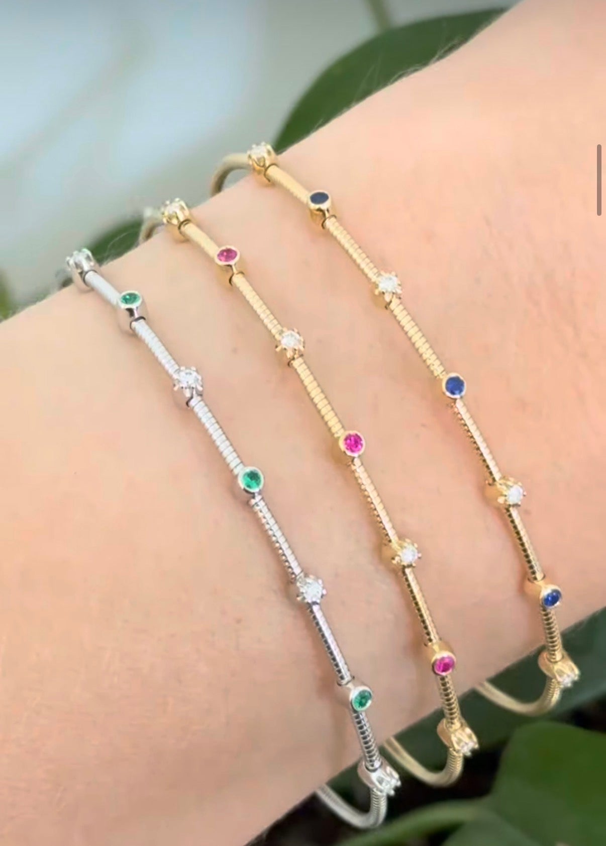 Natural diamond flex bracelets available in yellow gold with sapphires, yellow gold with rubies, and white gold with emeralds
