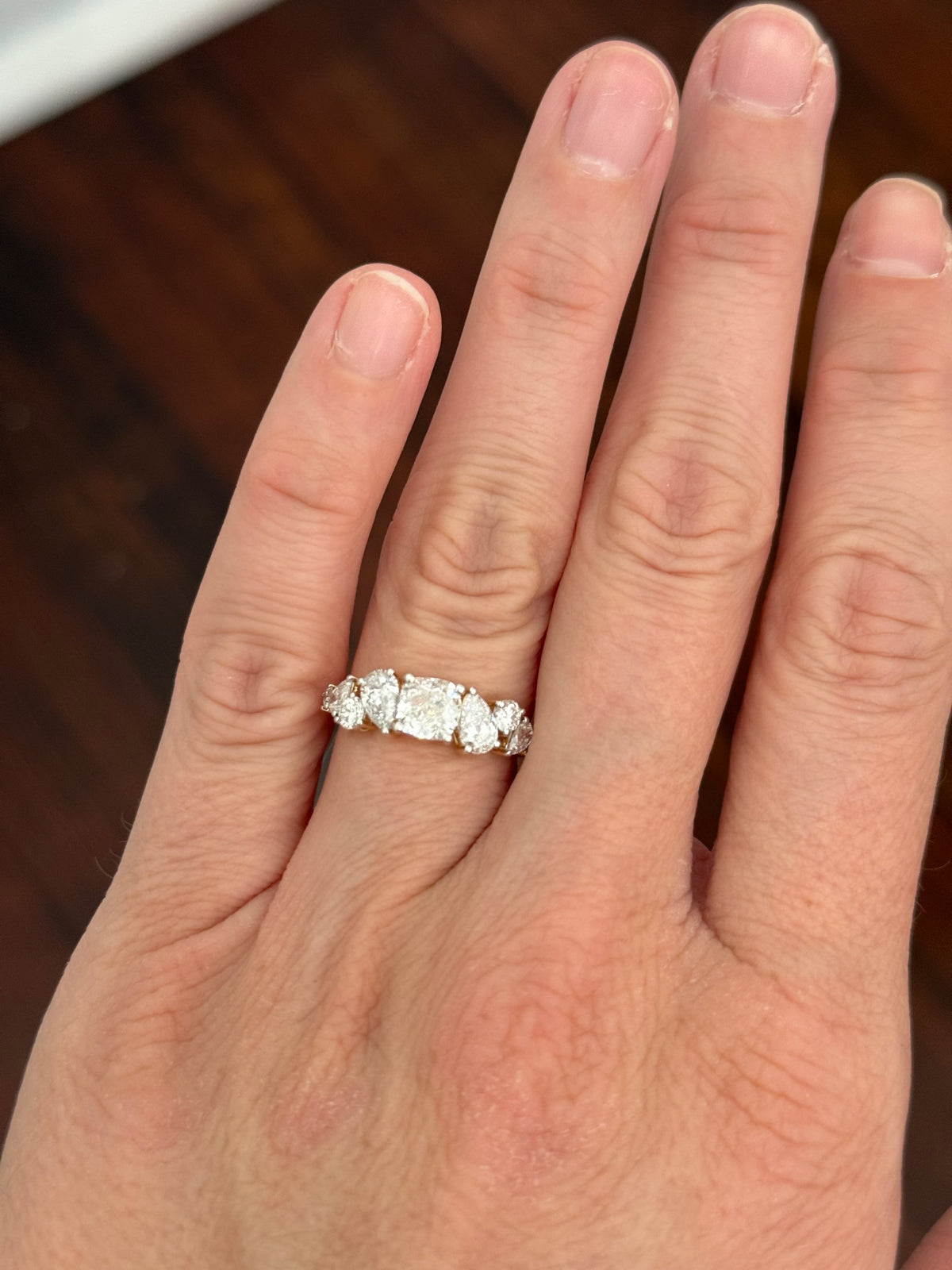 Yellow gold cushion, pear shape and round lab diamond ring. Prongs are white gold.