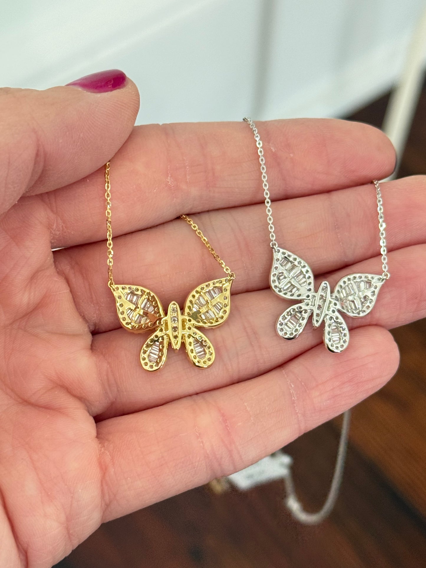 Butterfly necklaces with baguette and round diamonds available in white and yellow gold