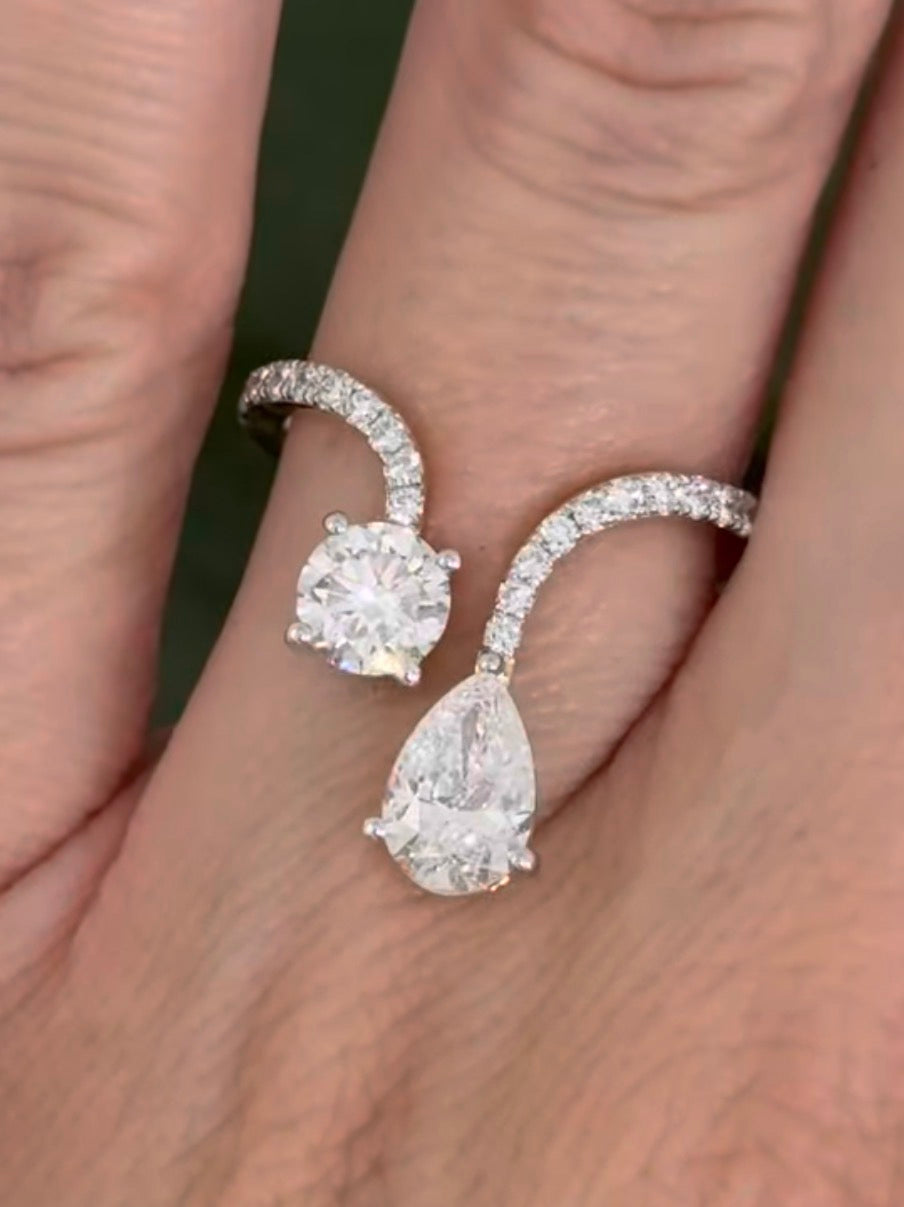 Yellow gold pear shape and round lab diamond ring. Prongs are white gold.