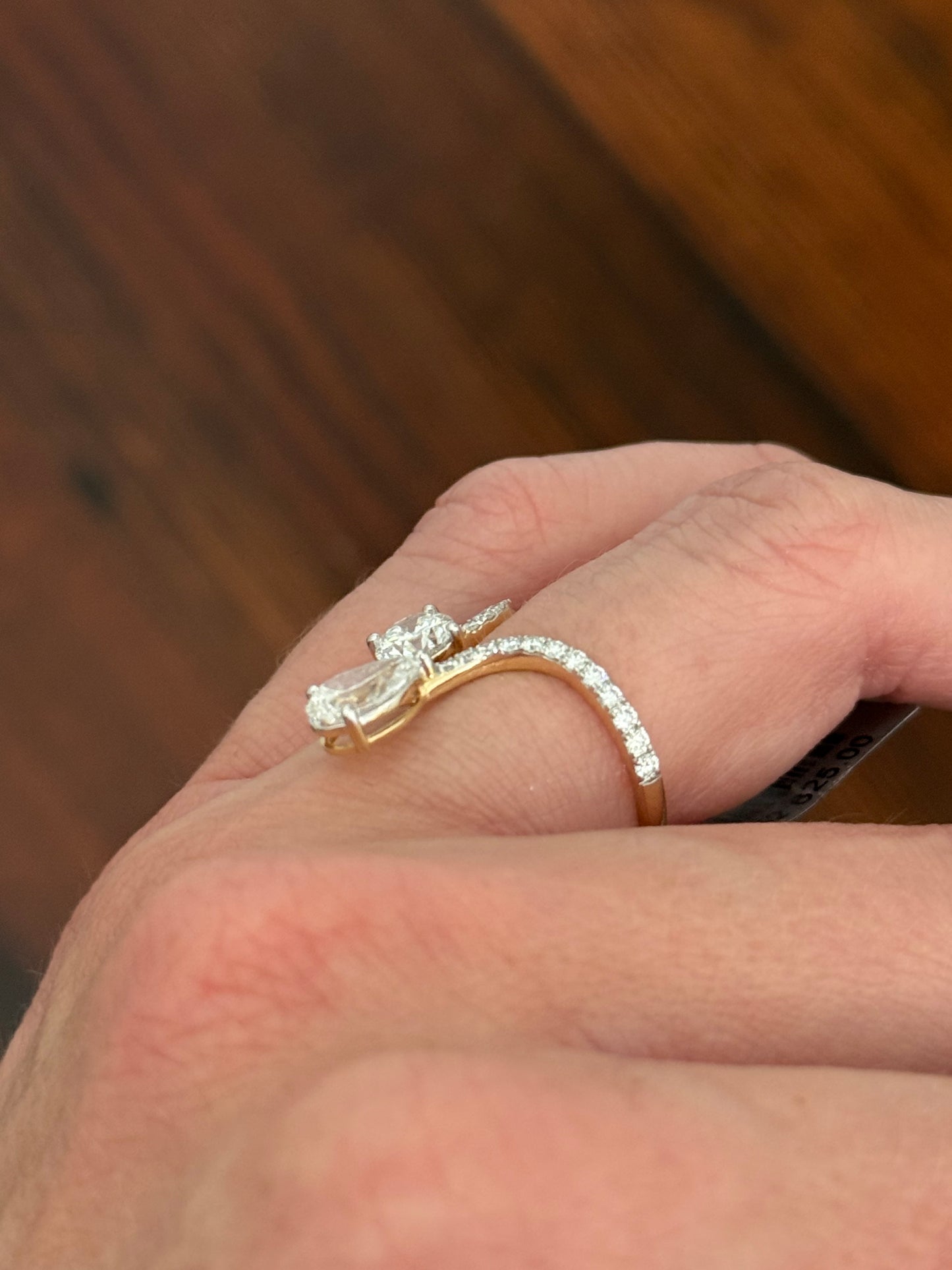 Yellow gold pear shape and round lab diamond ring. Prongs are white gold.