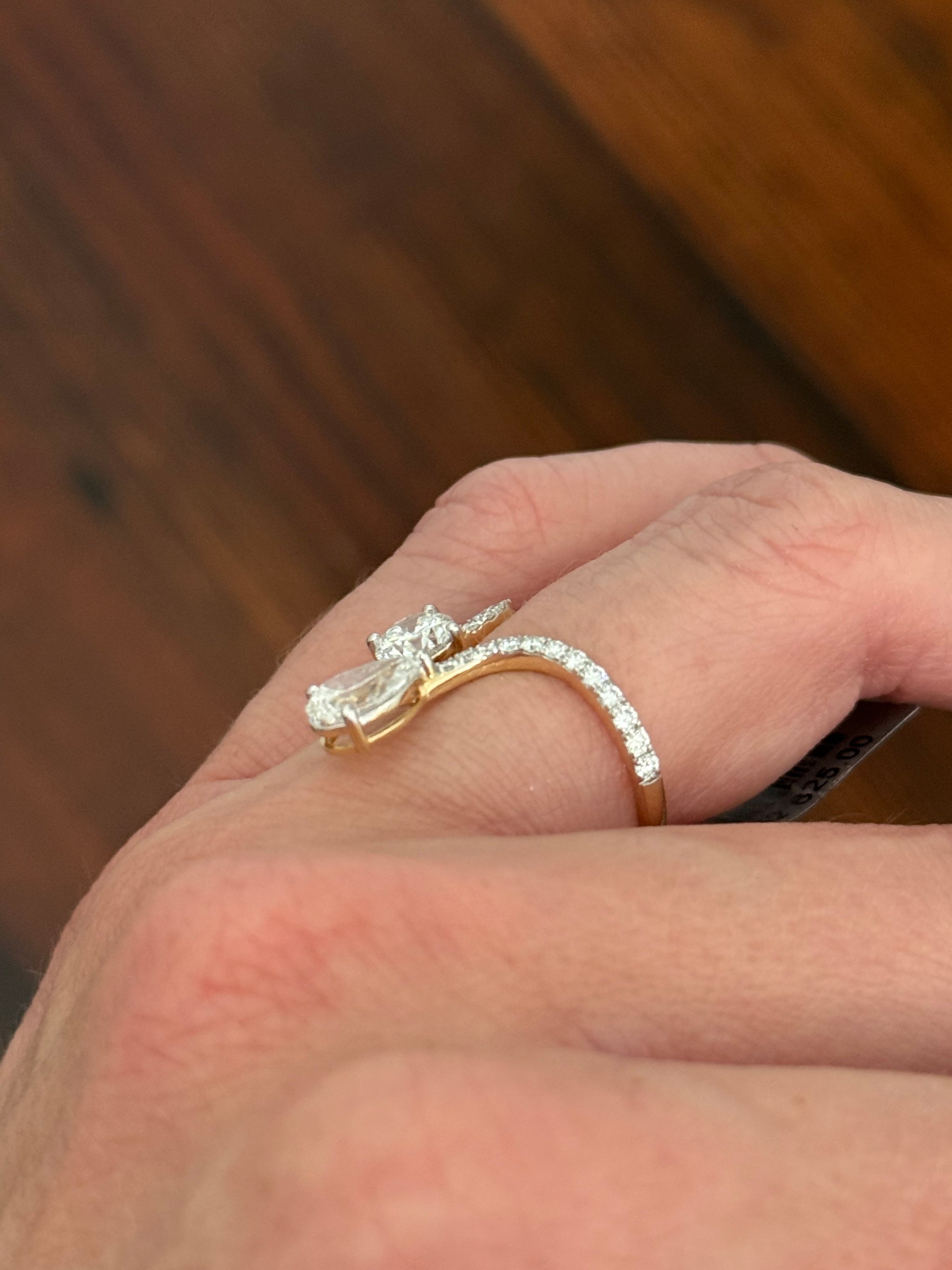 Yellow gold pear shape and round lab diamond ring. Prongs are white gold.