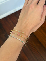 Natural diamond flex bracelets available in yellow gold with sapphires, yellow gold with rubies, and white gold with emeralds
