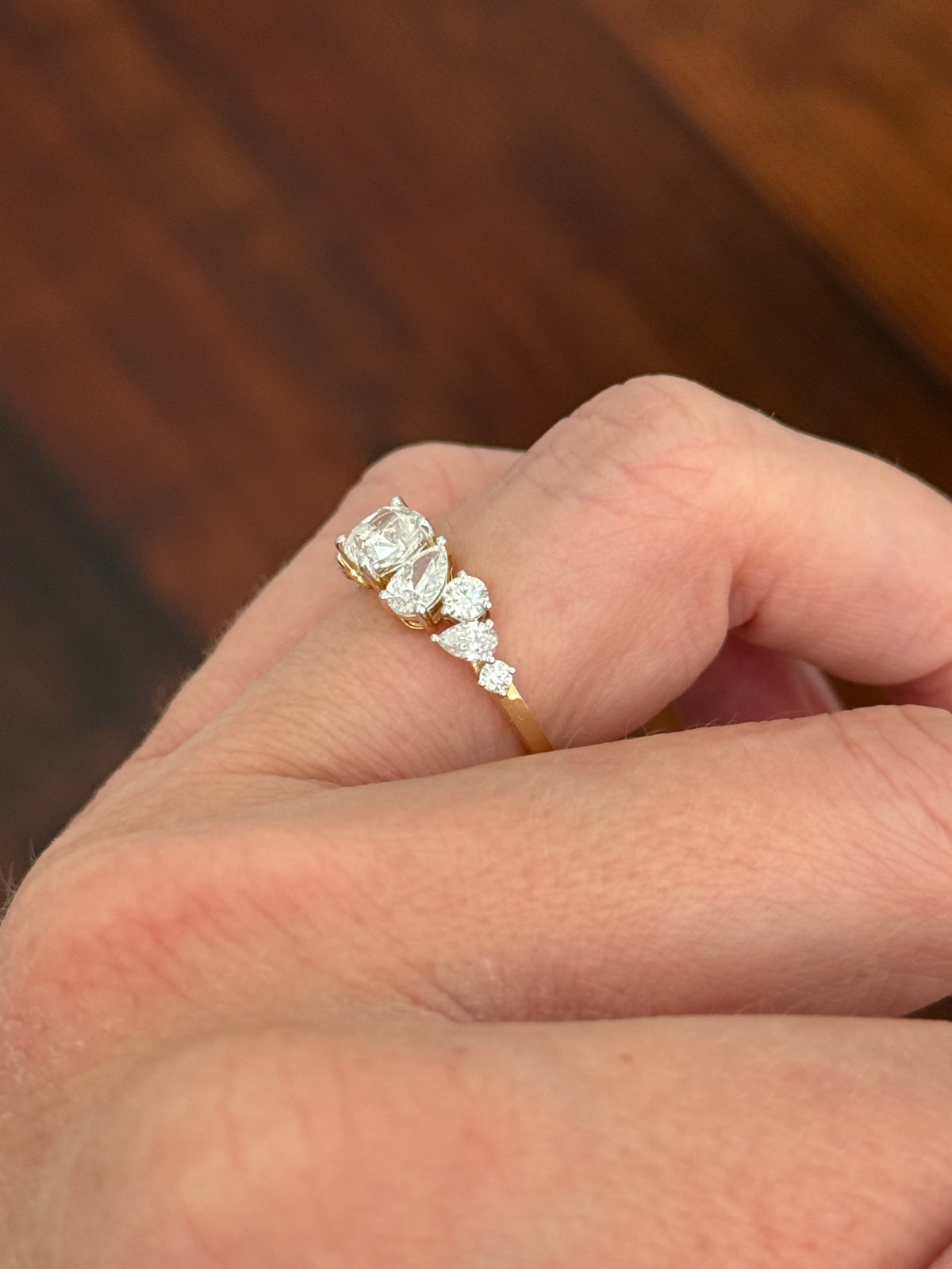 Yellow gold cushion, pear shape and round lab diamond ring. Prongs are white gold.